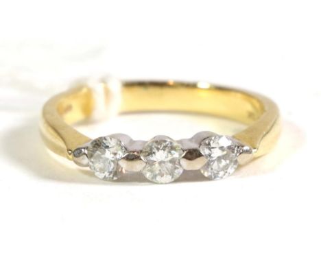 An 18 carat gold three stone diamond ring, total estimated diamond weight 0.45 carat approximately, finger size K1/2.  Gross 