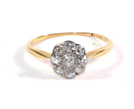 A diamond flowerhead cluster ring, stamped '18ct'.  Gross weight - 1.64 grams. Band misshapen and unable to measure. 