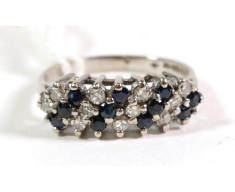 An 18 carat white gold diamond and sapphire three row ring, total estimated diamond weight 0.25 carat approximately, finger s