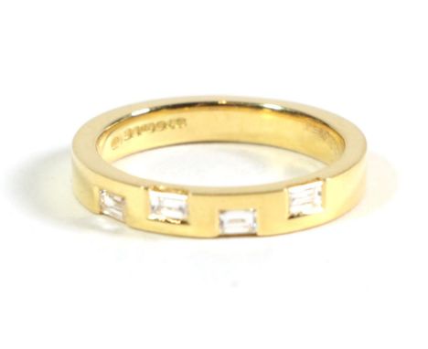 An 18 carat gold diamond band ring, inset with four baguette cut diamonds, total estimated diamond weight 0.40 carat approxim