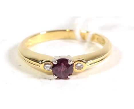 An 18 carat gold ruby and diamond three stone ring, finger size N1/2. Gross weight - 3.94 grams. 