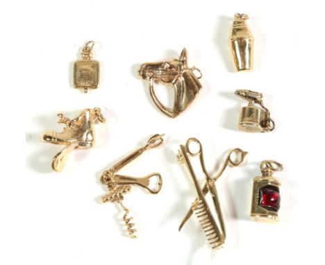 A 9 carat gold brooch depicting scissors and a comb, length 3.75cm; and seven assorted 9 carat gold charms including a boot, 