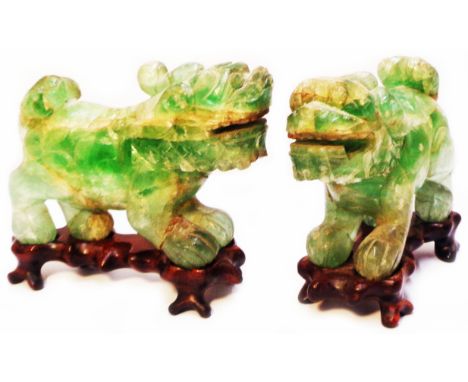 A pair of Chinese carved jade temple lions each set on a carved hardwood stand - both a/f