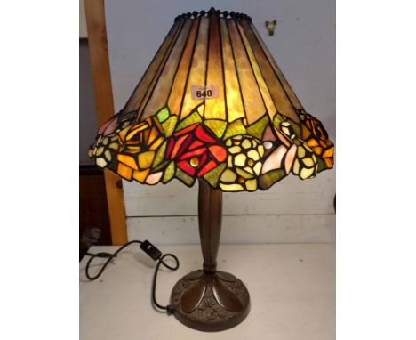 A large Tiffany style table lamp on decorative metal base