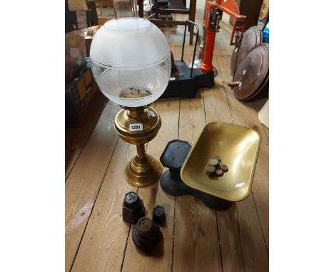 A brass oil lamp with chimney and frosted decorative shade - sold with a set of cast iron scales with brass pan and weights