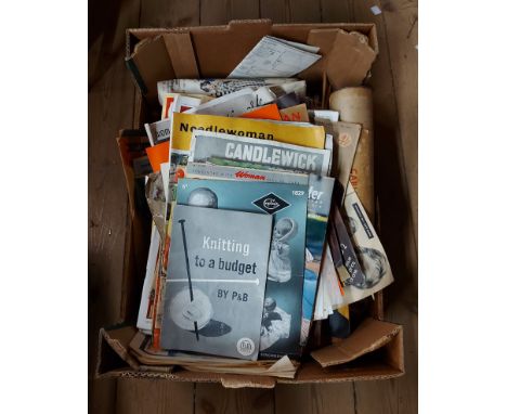 A box containing vintage knitting patterns, 'Woman's Own' magazines, knitting needles, etc.