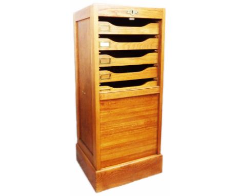 A 42cm vintage light oak tambour fronted filing chest with nine internal slides with brass name holders, set on plinth base -