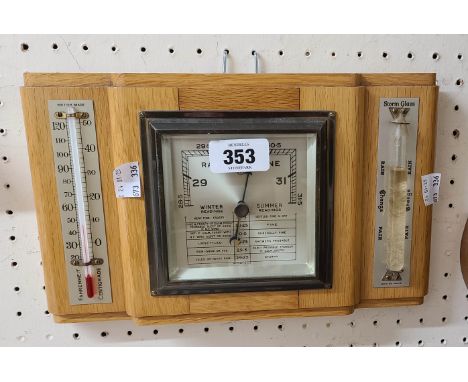 A vintage golden oak framed Anchor Brand aneroid wall barometer with flanking thermometer scale and storm glass