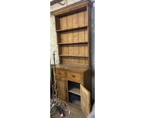 A 95cm old pine two part dresser with three shelf open plate rack over a base with two short drawers and double panelled cupb