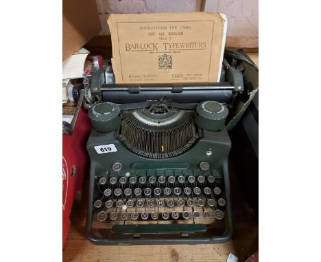 A vintage bar-lock typewriter with cover and instructions