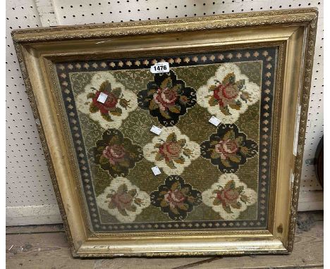 A gilt framed old tapestry panel depicting a repeat rose pattern within a decorative border