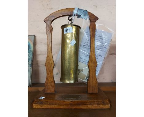 A first World War Trench Art brass shell gong with chased decoration on oak stand made by German prisoners of war and present