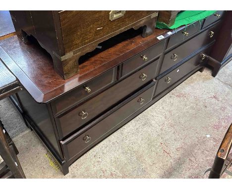 A 1.56m vintage Stag 'Minstrel' mahogany chest with two banks of two short and two long drawers, set on bracket base