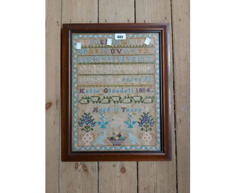 A framed embroidered alphabet sampler by Katie Gleadle aged 11, dated 1884