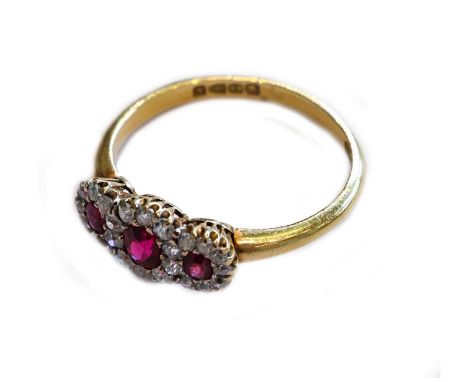 An 18 carat gold synthetic ruby and diamond triple cluster ring, the graduated round cut synthetic rubies within borders of o