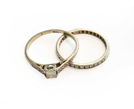 A diamond solitaire ring with diamond set shoulders, stamped 'PLAT', finger size N; and a diamond half hoop ring, unmarked, f