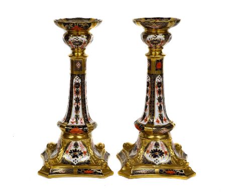 A pair of Royal Crown Derby Imari candlesticks, pattern 1128, raised on square spreading bases moulded with four dolphins, pr