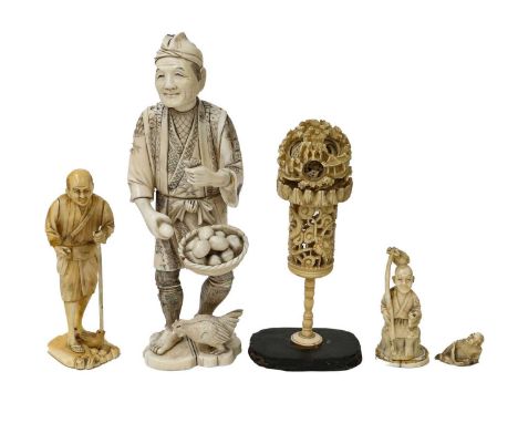 A Japanese Meiji period sectional ivory okimono carved as a farm worker, a smaller example, a figural netsuke, a further carv