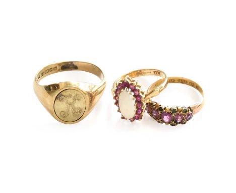 A 9 carat gold signet ring, finger size W1/2; a 15 carat gold garnet and emerald ring, finger size L1/2; and a 9 carat gold o