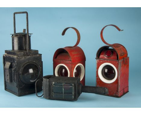 Four vintage transport and related lamps,  two red signalling examples, one large black railway lamp and a black carriage lam