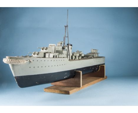 A vintage scratchbuilt remote control model of a battleship or destroyer, black and grey, deck with gun turrets and torpedo l