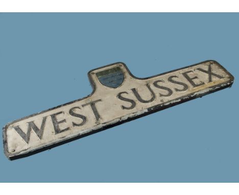 A vintage County sign, "West Sussex", a cast aluminium example mounted on wooden backing with heraldic shield above, 106.5cm 