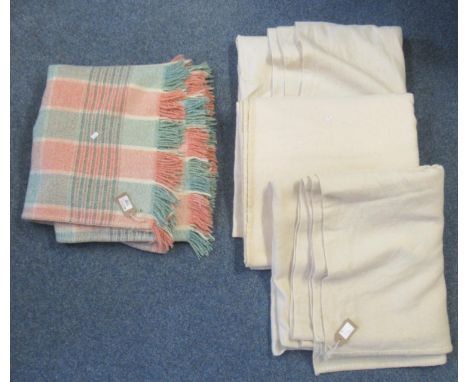 Four vintage woollen blankets; one orange and green check with 1940's utility label, three undyed plain cream blankets one wi