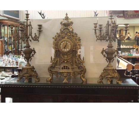 Highly ornate brass clock set, candelabra 67cm high.