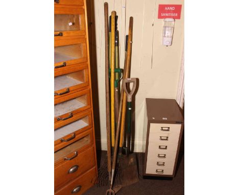 Collection of gardening hand tools including rakes, fork, spade, etc.