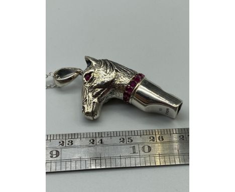 A Sterling silver horse head whistle with ruby eyes on a silver chain. 