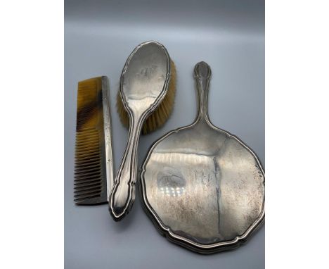 A Birmingham silver three piece dressing table set. Includes mirror, brush and comb. 