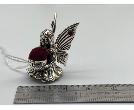A Sterling silver fairy pin cushion designed with two ruby stones. 