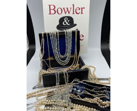 Antique leather jewel box containing a quantity of vintage pearl and opalescent bead necklaces. 