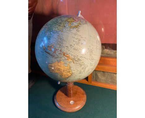 An Art Deco desk top globe. Designed with a wooden base detailed with a small compass. Finished with a chrome scale bracket. 