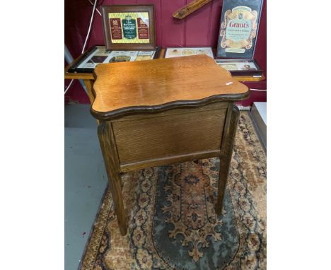 A vintage light oak sewing /backgammon table. Designed with a lift up and swivel top. [62cm height] 