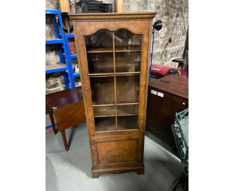 Antique style tall narrow display cabinet. Designed with a glass panel door and fitted shelf interior. 