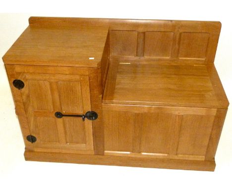 A Robert 'Mouseman' Thompson Adze oak telephone seat/lamp tableHaving hinged seat flanked by single panelled cupboard door ha