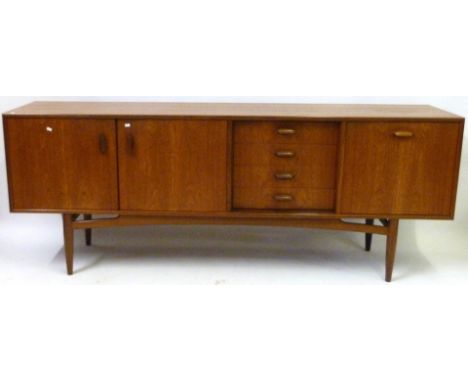 A mid Century teak sideboardHaving two panelled cupboard doors, four drawers and a pull down cupboard door, height 78.5cm, le
