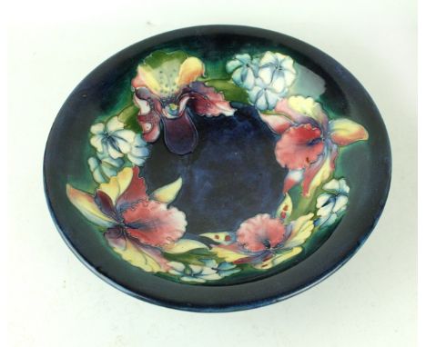 A Walter Moorcroft bowl of circular formDecorated in the 'Orchid' pattern on a blue ground, blue signature and impressed mark