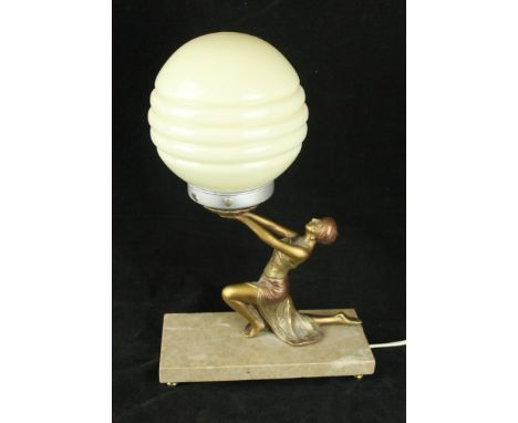 An Art Deco cold painted spelter table lampModelled in the form of a kneeling girl supporting a green glass shade, height 36c