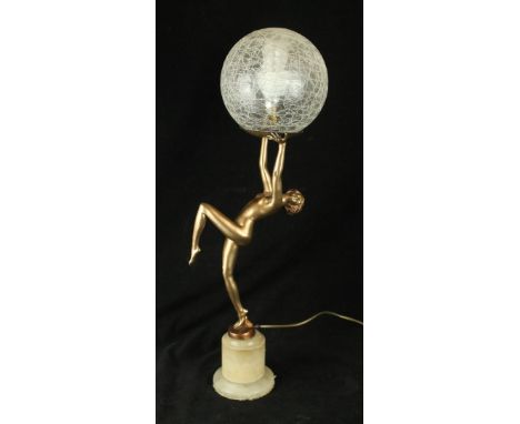 An Art Deco spelter figural table lampModelled in the form of a scantily clad dancing girl supporting a crackle glass shade, 