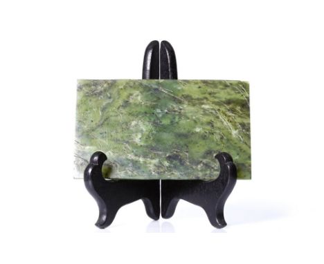 an antique , Chinese, spinach, colored jade, depicting a boy with a cage and bird. The boy and a bird in a bamboo grove on th