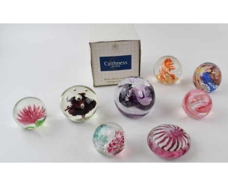 A collection of glass paperweights to include a boxed example by Caithness, Scotland. (8)  In good condition.