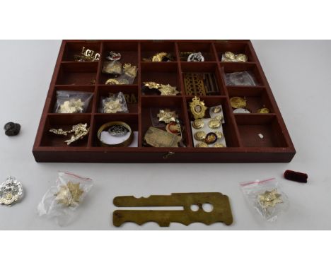A quantity of military items to include belt buckles, badges, pips, lapels, cloth badges and a brass button polisher. All hou