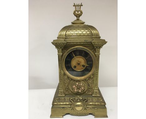 A Victorian brass mantel clock with a dome top and ornate pilasters. French movement. Height 48cm.