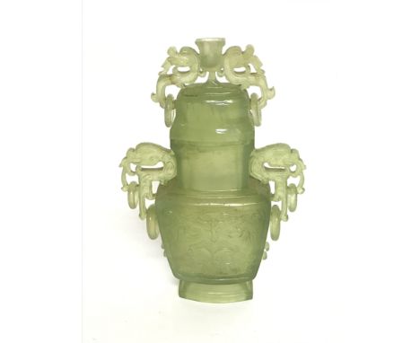 A jade vase decorated with dragons and symmetrical patterns. 18cm tall approx. Postage cat D