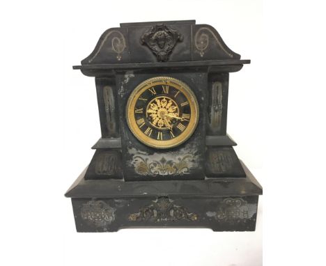 A Victorian black slate mantel clock with raised gilded Roman numerals.