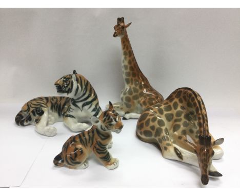 Four Lomonosov ceramic figures comprising a tiger, tiger cub and two giraffes (4). Shipping category D.