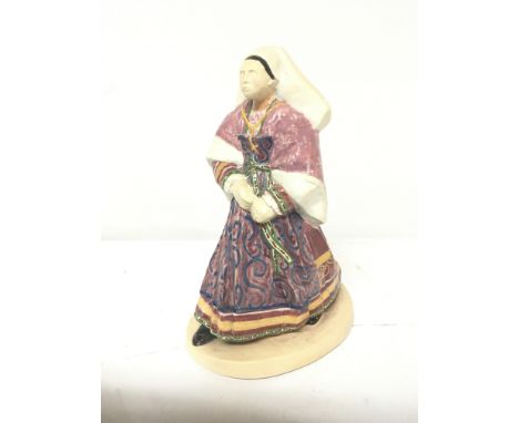 An Early example of Henriot Quimper hand painted figure a lady in traditional dress with signed base. Hight 26cm. No obvious 