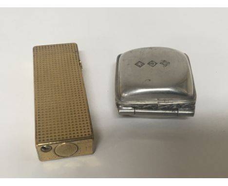 A Vintage gold plated Dunhill lighter and a white metal pill box with impressed marks. (2)